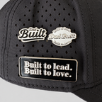 Dad Built three-pin set displayed on a black perforated cap against a studio-gray background